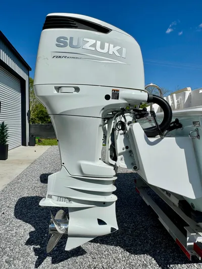  Yacht Photos Pics 2023 Twin Vee 280 GFX CC with Suzuki outboard motor, parked on gravel.