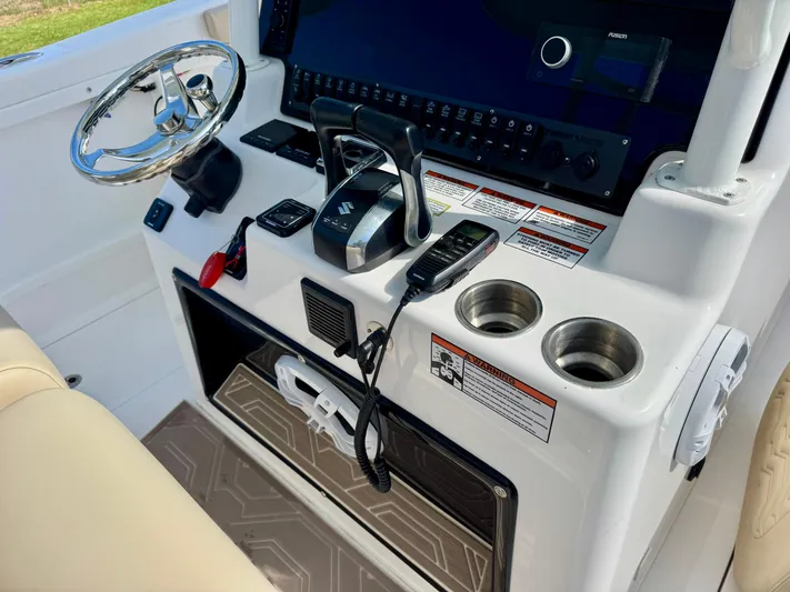  Yacht Photos Pics 2023 Twin Vee 280 GFX CC boat console with steering wheel, controls, and cup holders.