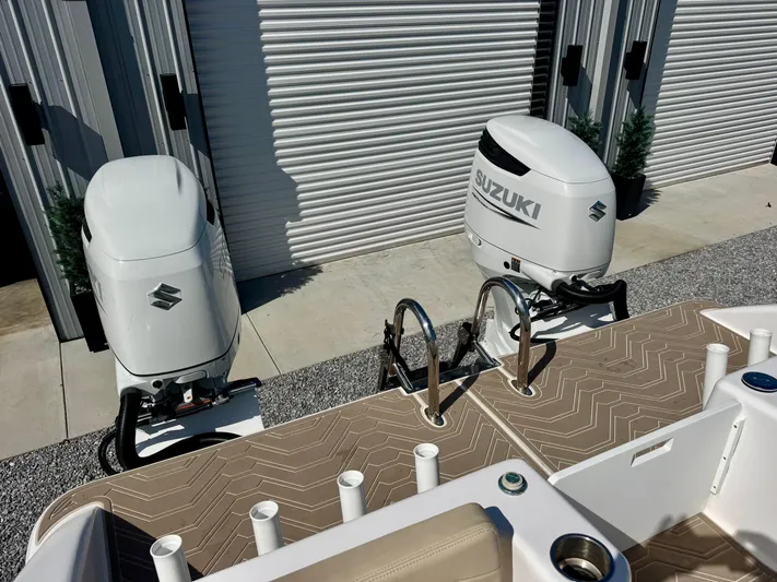  Yacht Photos Pics 2023 Twin Vee 280 GFX CC boat with dual Suzuki outboard motors, docked near storage units.