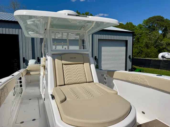  Yacht Photos Pics 2023 Twin Vee 280 GFX CC boat with beige seating, docked near metal buildings.