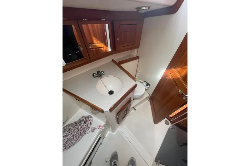 Spray Yacht Photos Pics Bathroom interior of a 2002 Tartan 37 yacht with wooden cabinets and white fixtures.