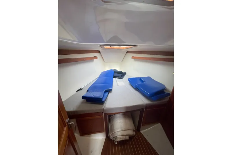 Spray Yacht Photos Pics Cozy cabin interior of 2002 Tartan 37 sailboat with blue cushions and wooden accents.