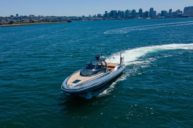 Quikwood Yacht Photos Pics Luxury 2014 SACS Strider yacht cruising in blue ocean near city skyline.