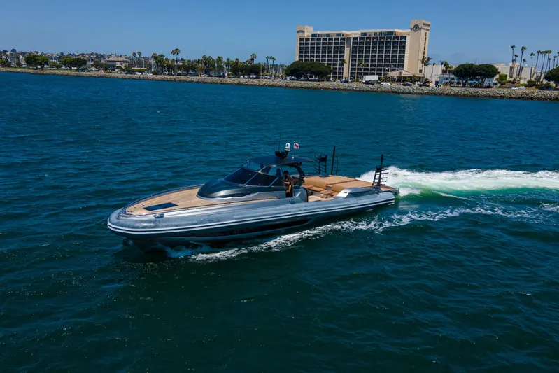 Quikwood Yacht Photos Pics 2014 SACS Strider yacht cruising on blue ocean near coastal cityscape.