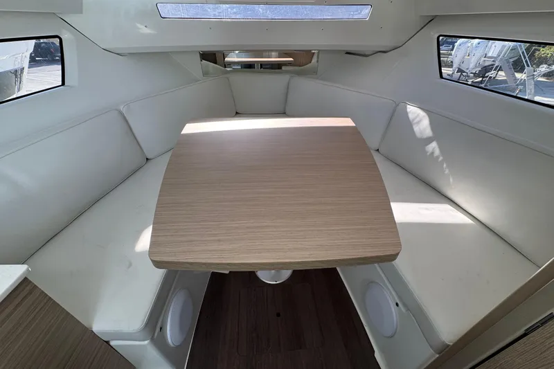  Yacht Photos Pics Interior of 2026 Jeanneau Leader 9.0 WA Series 2 with cozy seating and wooden table.
