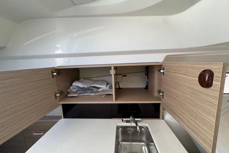  Yacht Photos Pics 2026 Jeanneau Leader 9.0 WA Series 2 interior with open wooden cabinets and sink.