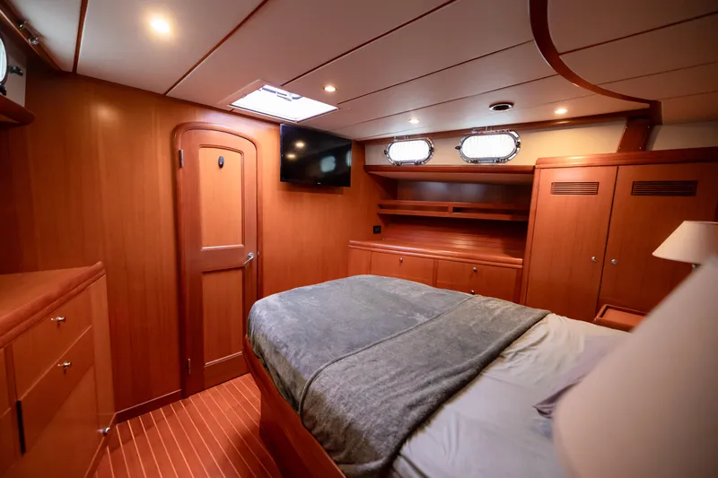  Yacht Photos Pics Luxurious cabin interior of 2009 Nordhavn 56 Motorsailer with wood finish and cozy bedding.