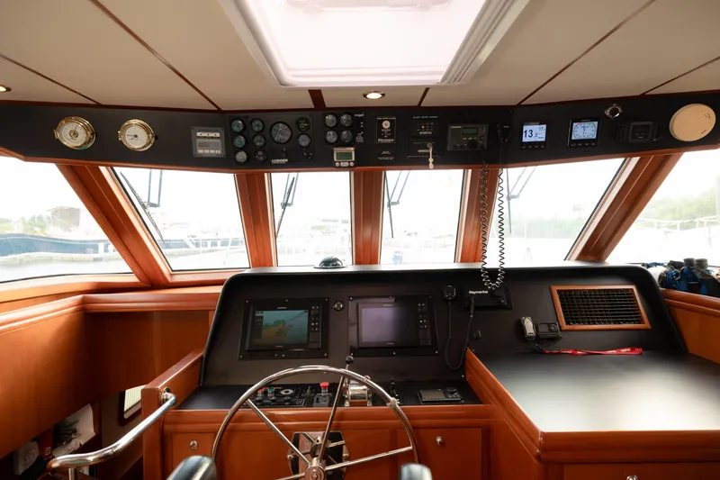  Yacht Photos Pics 2009 Nordhavn 56 Motorsailer helm with navigation instruments and wooden interior.