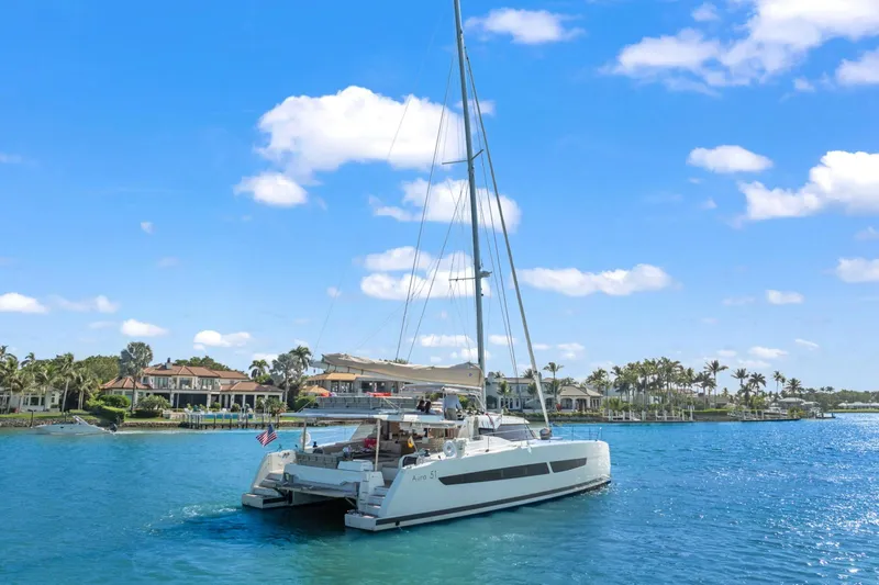 Halcyon Yacht Photos Pics 2024 Fountaine Pajot Aura 51 Catamaran sailing in a scenic coastal area.