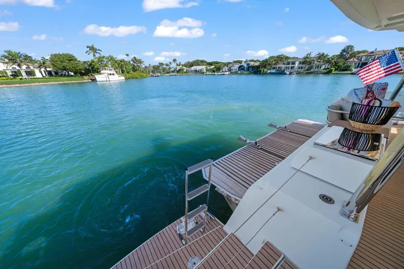 Halcyon Yacht Photos Pics 2024 Fountaine Pajot Aura 51 Catamaran on serene blue water with American flag.