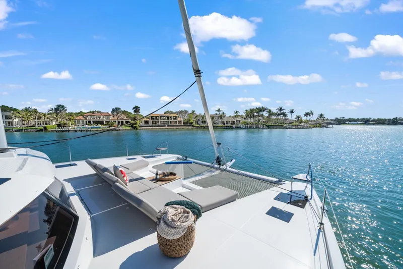 Halcyon Yacht Photos Pics 2024 Fountaine Pajot Aura 51 Catamaran on serene water with luxurious deck view.