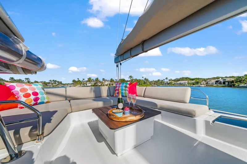 Halcyon Yacht Photos Pics Luxurious 2024 Fountaine Pajot Aura 51 Catamaran deck with colorful cushions and refreshments.