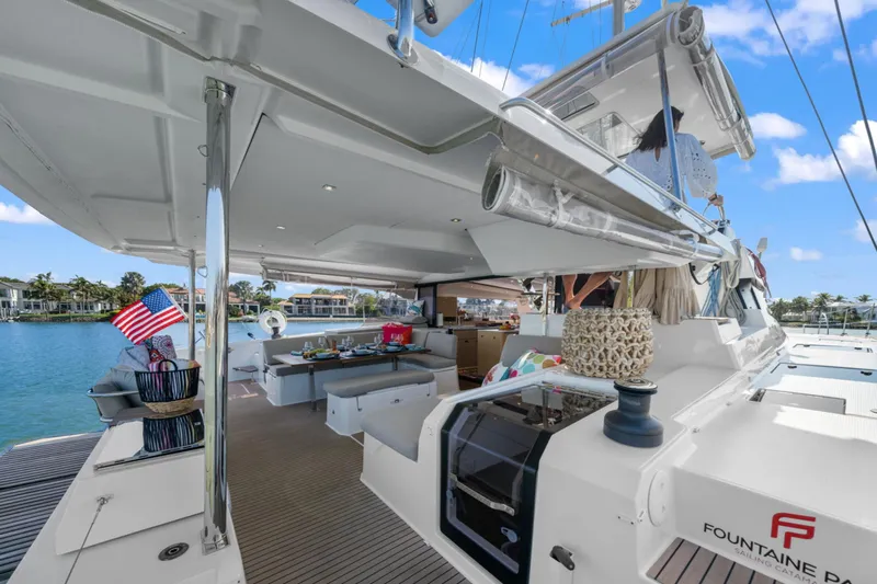 Halcyon Yacht Photos Pics 2024 Fountaine Pajot Aura 51 Catamaran, luxurious deck with seating and dining area.