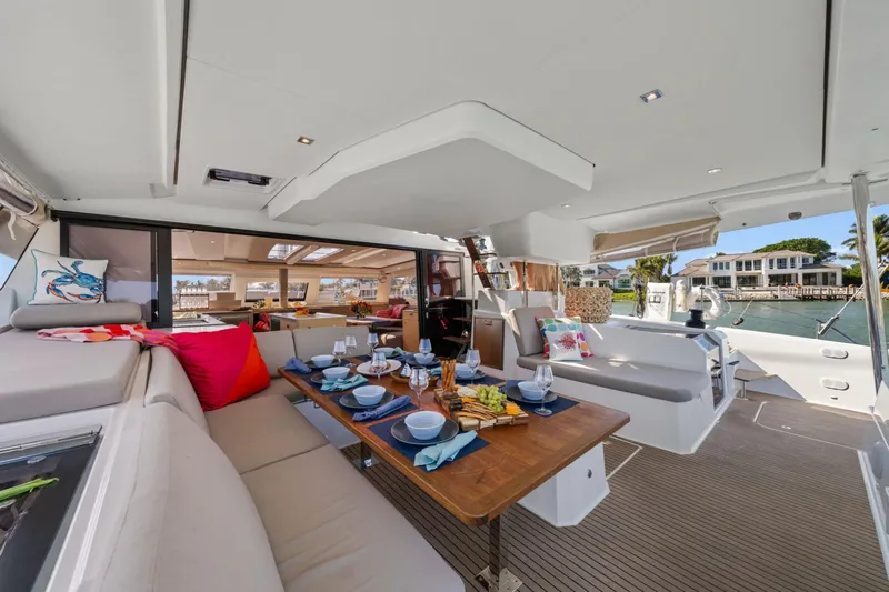 Halcyon Yacht Photos Pics 2024 Fountaine Pajot Aura 51 Catamaran interior with elegant dining setup and waterfront view.