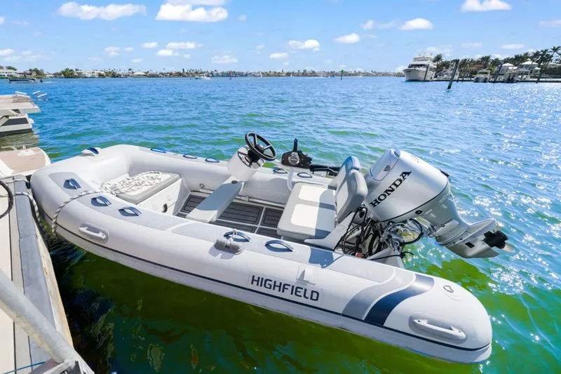 Halcyon Yacht Photos Pics Highfield inflatable boat with Honda motor docked on clear blue water.