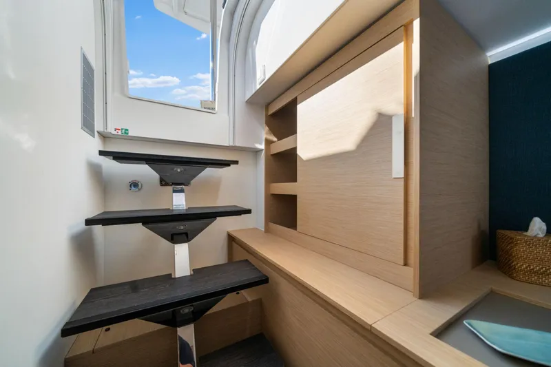 Halcyon Yacht Photos Pics Interior of 2024 Fountaine Pajot Aura 51 Catamaran, featuring modern stairs and wooden cabinetry.