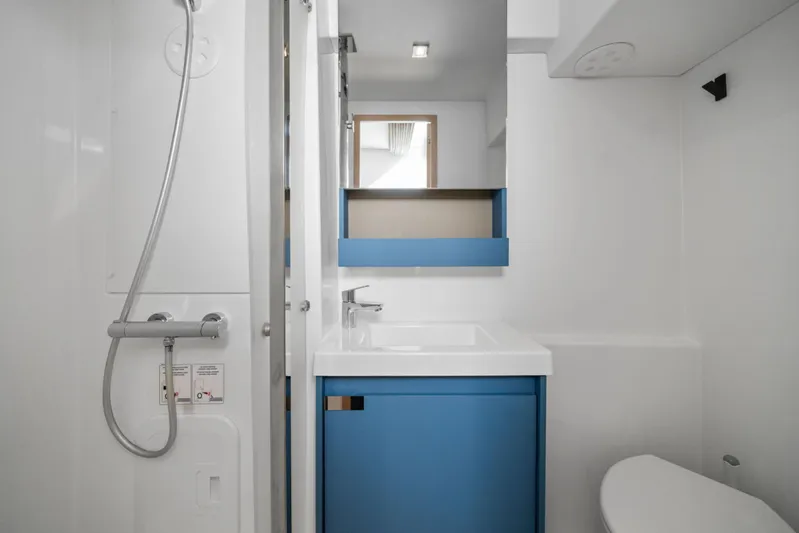 Halcyon Yacht Photos Pics 2024 Fountaine Pajot Aura 51 Catamaran bathroom with modern shower and blue vanity.