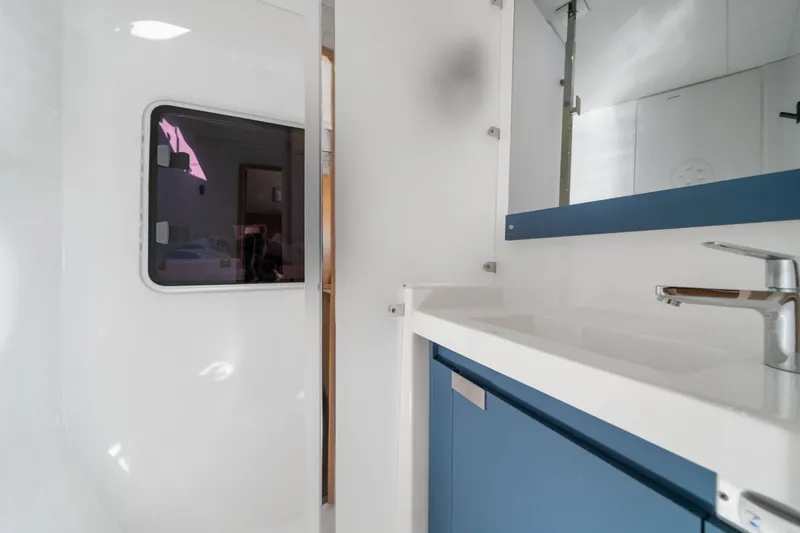 Halcyon Yacht Photos Pics 2024 Fountaine Pajot Aura 51 Catamaran bathroom with modern sink and mirror.