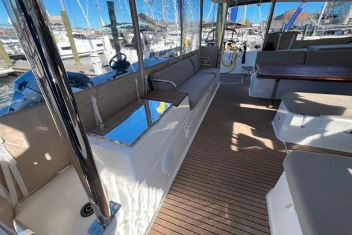 Halcyon Yacht Photos Pics 2024 Fountaine Pajot Aura 51 Catamaran interior with spacious seating and wooden flooring.