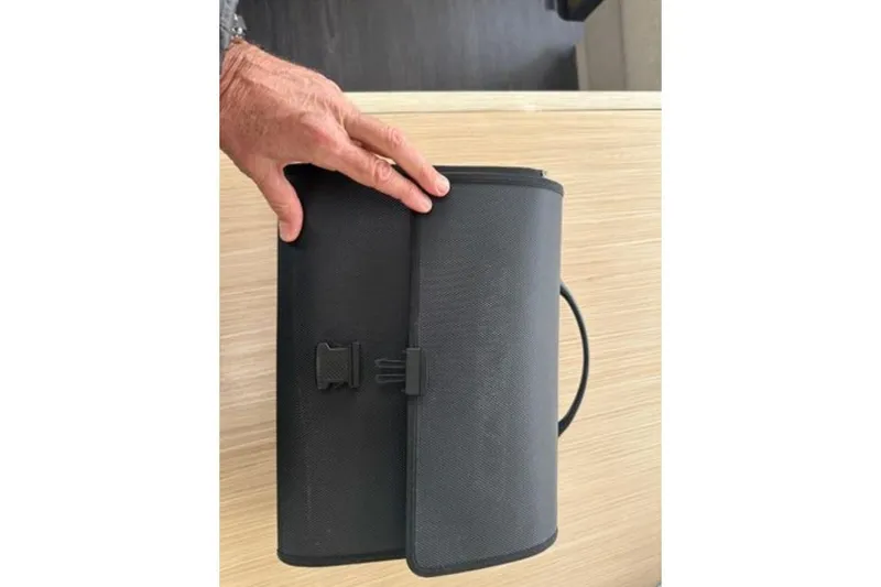 Halcyon Yacht Photos Pics Hand holding a black case on a wooden surface, related to Fountaine Pajot Aura 51 Catamaran 2024.