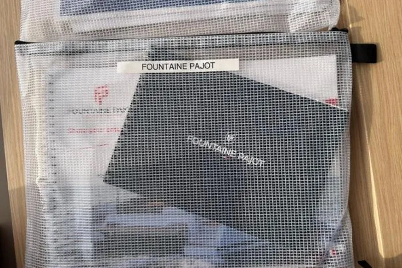 Halcyon Yacht Photos Pics Mesh bag containing Fountaine Pajot Aura 51 Catamaran 2024 documents and booklet.