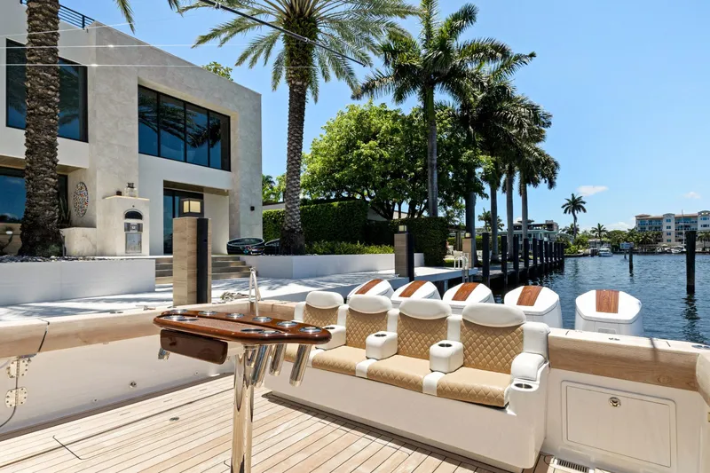 Book Ends Yacht Photos Pics Luxurious 2021 HCB Estrella yacht docked by modern waterfront home with palm trees.