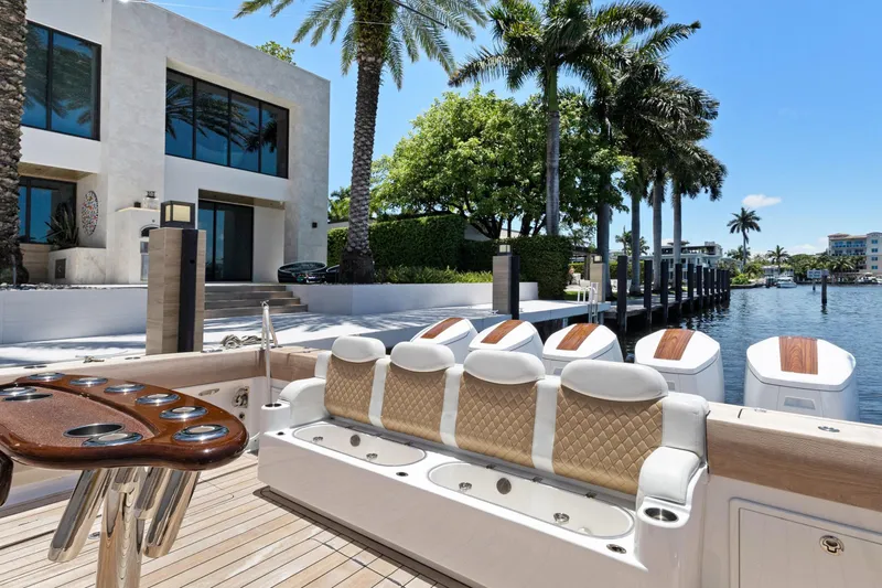 Book Ends Yacht Photos Pics Luxurious 2021 HCB Estrella yacht docked by a modern waterfront home with palm trees.