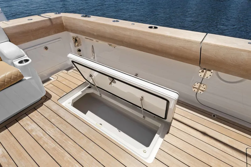 Book Ends Yacht Photos Pics 2021 HCB Estrella boat deck with open storage compartment, featuring wood finish and seating.