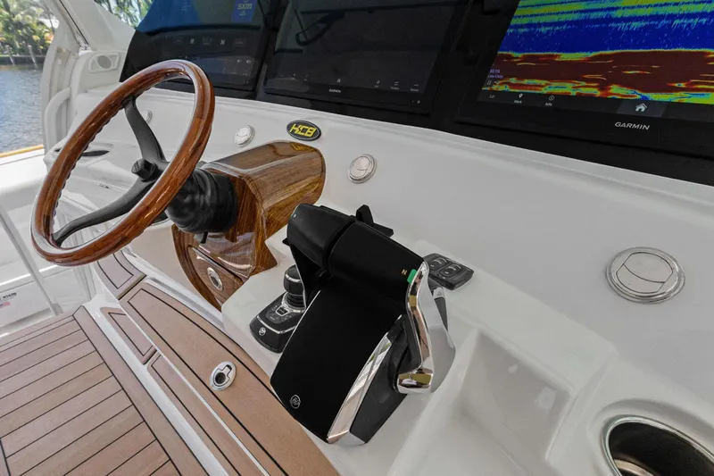 Book Ends Yacht Photos Pics 2021 HCB Estrella boat dashboard with wooden steering wheel and Garmin navigation displays.