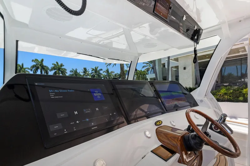 Book Ends Yacht Photos Pics 2021 HCB Estrella boat dashboard with modern navigation screens and wooden steering wheel.