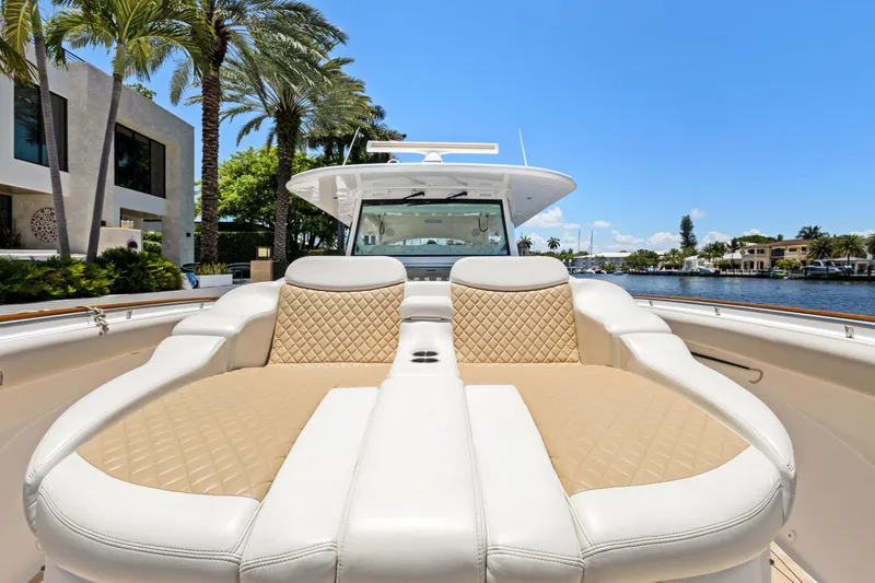 Book Ends Yacht Photos Pics 2021 HCB Estrella boat with luxurious seating, docked near waterfront homes and palm trees.