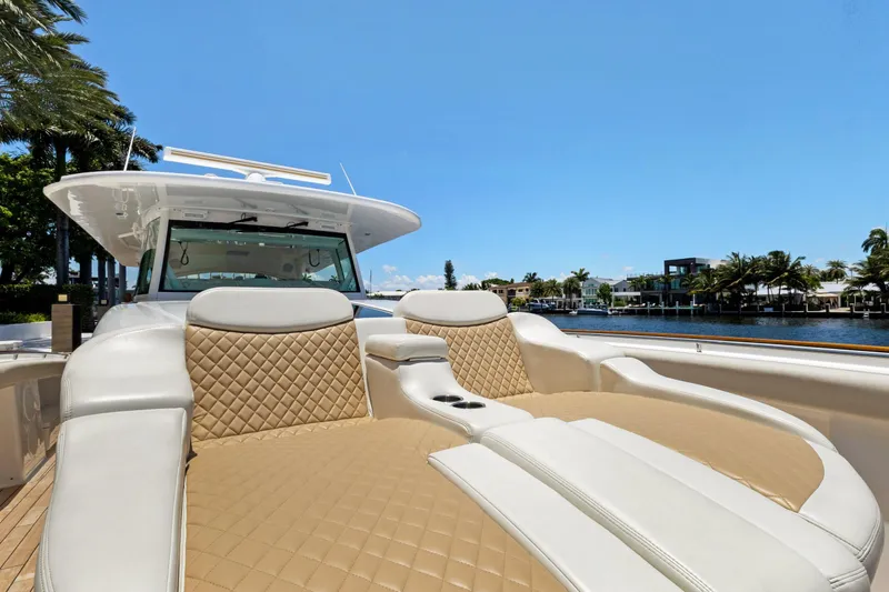 Book Ends Yacht Photos Pics Luxurious 2021 HCB Estrella yacht with plush seating, docked by palm trees and waterfront homes.