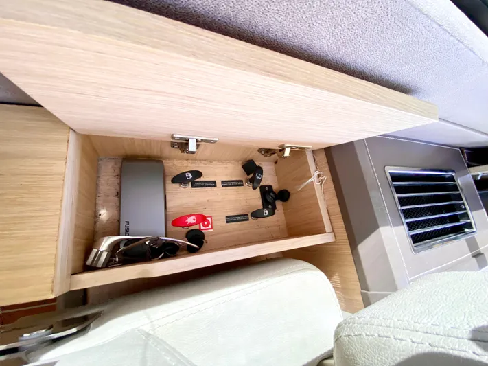 Revenant Yacht Photos Pics Open storage compartment in 2015 Monte Carlo MC5S with keys and sunglasses.