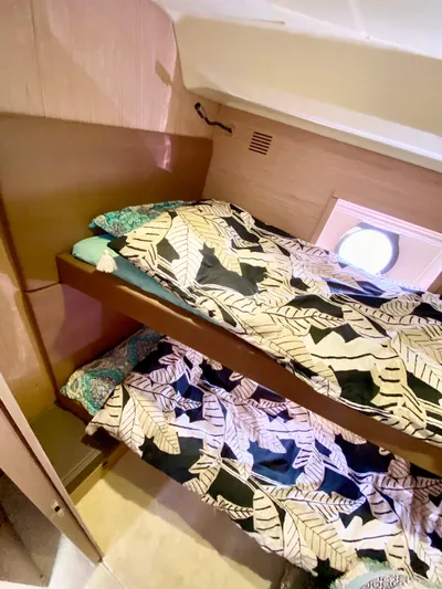 Revenant Yacht Photos Pics Bunk beds in 2015 Monte Carlo MC5S yacht cabin with patterned bedding and porthole window.