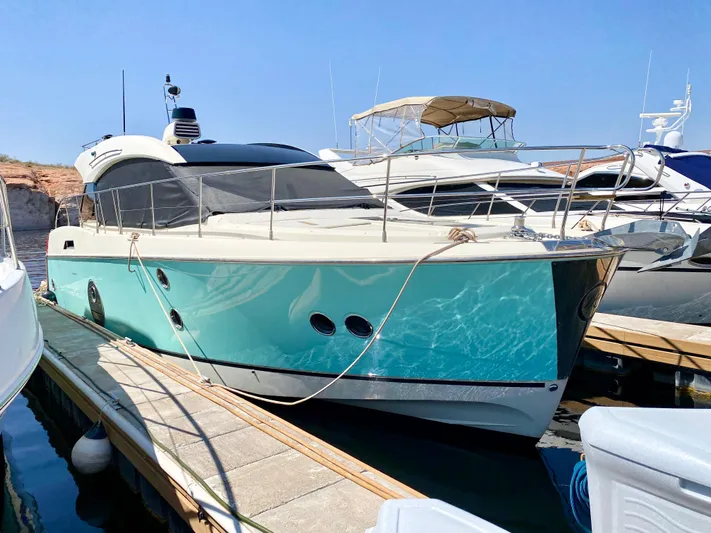 Revenant Yacht Photos Pics 2015 Monte Carlo MC5S yacht docked at marina, turquoise hull, sleek design.