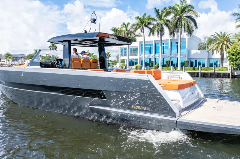  Yacht Photos Pics 2020 Fjord 44 Open yacht cruising near waterfront property with palm trees.