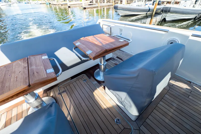  Yacht Photos Pics 2020 Fjord 44 Open yacht deck with wooden tables and cushioned seating.