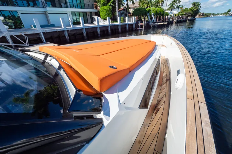  Yacht Photos Pics 2020 Fjord 44 Open yacht with orange sunbed, docked by waterfront homes.