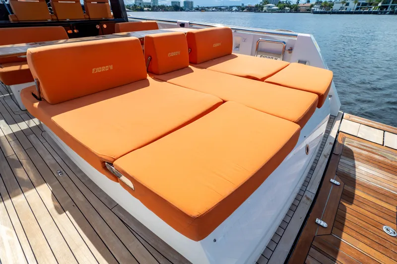  Yacht Photos Pics 2020 Fjord 44 Open yacht with orange sunbed cushions on deck by the water.