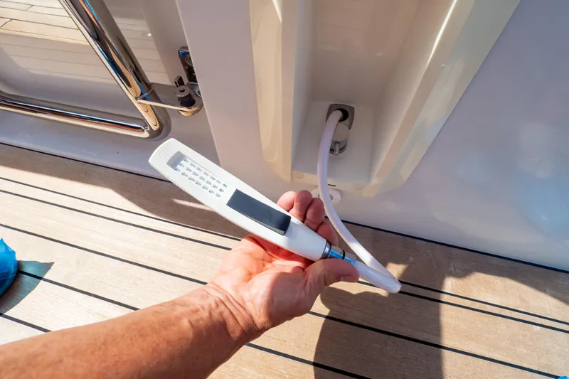  Yacht Photos Pics Hand holding a shower head on a 2020 Fjord 44 Open yacht deck.