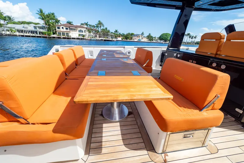  Yacht Photos Pics Luxurious 2020 Fjord 44 Open yacht with orange seating and wooden table on deck.