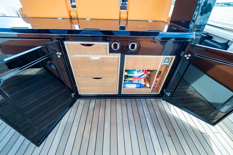  Yacht Photos Pics 2020 Fjord 44 Open yacht interior with open storage cabinets and wooden flooring.