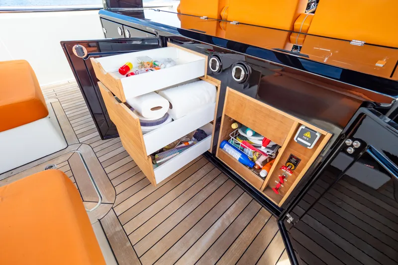 Yacht Photos Pics Luxury yacht Fjord 44 Open 2020 interior with open storage compartments and orange seating.