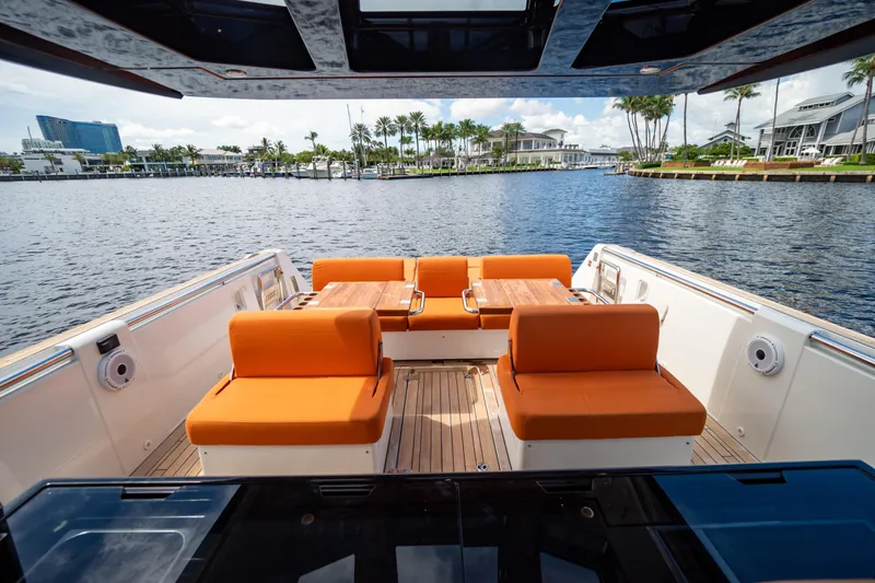  Yacht Photos Pics 2020 Fjord 44 Open yacht with orange seating, docked by waterfront homes.