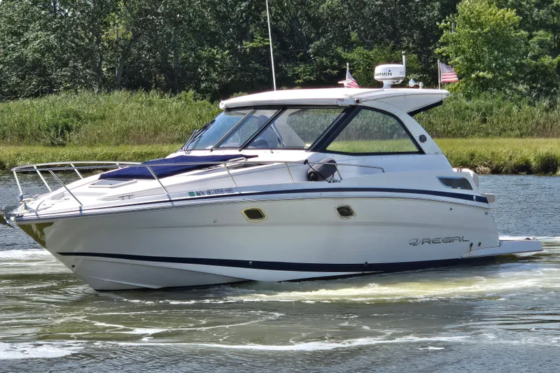  Yacht Photos Pics 2018 Regal 35 Sport Coupe cruising on a scenic waterway with lush greenery.