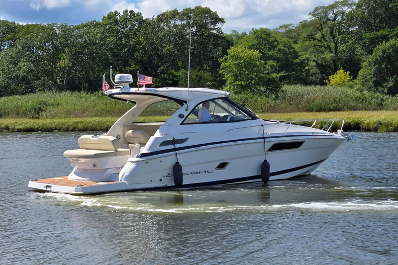  Yacht Photos Pics 2018 Regal 35 Sport Coupe cruising on a scenic river with lush greenery.