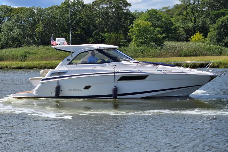  Yacht Photos Pics 2018 Regal 35 Sport Coupe cruising on a scenic waterway with lush greenery.