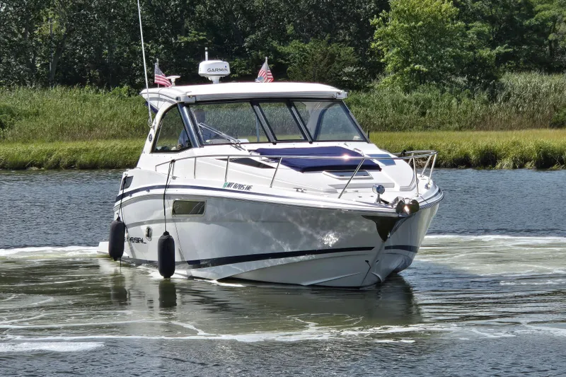  Yacht Photos Pics 2018 Regal 35 Sport Coupe cruising on a scenic river with lush greenery.