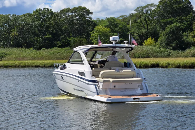  Yacht Photos Pics 2018 Regal 35 Sport Coupe cruising on a scenic river with lush greenery.
