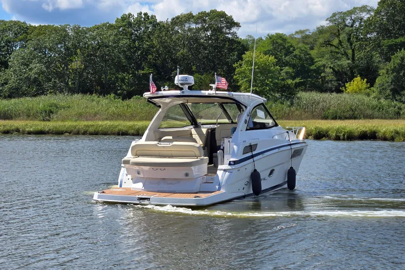  Yacht Photos Pics 2018 Regal 35 Sport Coupe cruising on a scenic river with lush greenery.